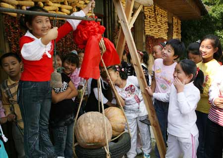 Students weigh a pumpkin at a park in Nantong, east China's Jiangsu Pronvince, Sept. 30, 2008. Students of Hetao primary school visited a farm park in the city to experience the farmers' life by learning some simple agricultural works. [Xinhua]