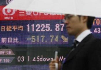 A man walks past an electronic board displaying falls in share prices in Tokyo September 30, 2008. Japan's Nikkei stock average slid nearly 5 percent on Tuesday to a three-year low after U.S. lawmakers rejected a $700 billion financial bailout plan, but later pulled back slightly.REUTERS/Issei Kato (JAPAN)