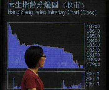 A passer-by looks at an electronic display showing a chart of the Hang Seng Index in Hong Kong September 29, 2008.(Bobby Yip/Reuters)