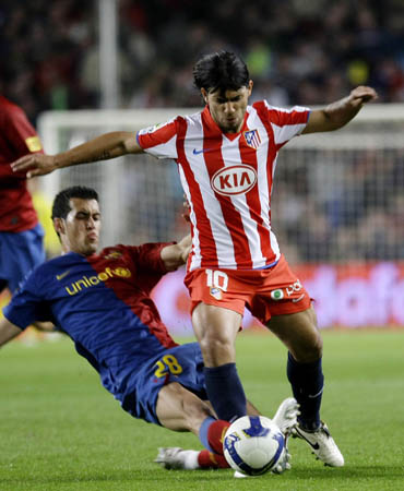 Barcelona's Sergi Busquets (L) challenges Atletico Madrid's Kun Aguero during their Spanish first division soccer match at Nou Camp stadium in Barcelona, October 4, 2008.