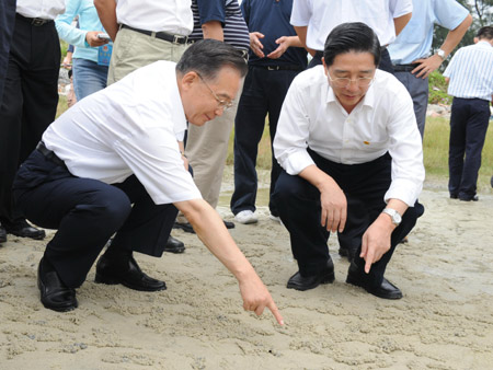 Chinese Premier Wen Jiabao (L) examines the condition of the beach in Beihai City, southwest China's Guangxi Zhuang Autonomous Region, Oct. 4, 2008. [Xinhua] 