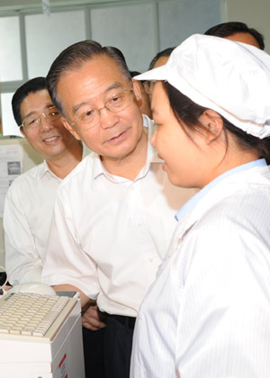 Chinese Premier Wen Jiabao (2nd L) talks with a worker as he visits Guangxi Changcheng Computer Co., Ltd. in Beihai City, southwest China's Guangxi Zhuang Autonomous Region, Oct. 4, 2008. [Xinhua] 