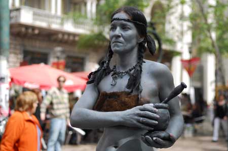 A woman presents a human sculpture of a Charrua Indian on a street in Montevideo, Uruguay, Oct. 4, 2008.