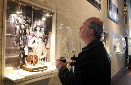 A man drinks tea while watching an old photo at the museum of carnivals in Montevideo, Uruguay, Oct. 4, 2008. 