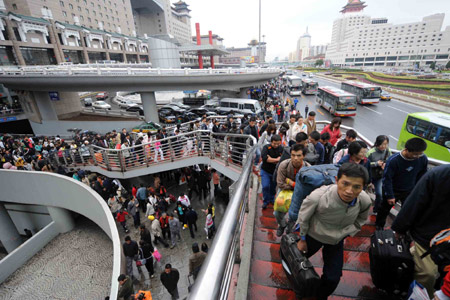 Passengers walk on an overpass at the Beijing West Railway Staion in Beijing, capital of China, on Oct. 5, 2008. The railway station witnessed a travel peak on Oct. 5, the last day of the weeklong National Day holidays. 