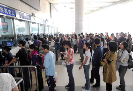 Passengers queue to buy tickets at the Chongqing North Railway Station in Chongqing, southwest China, Oct. 5, 2008.