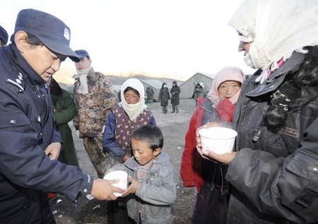A rescuer delivers food to local residents at Yangyi Village, the epicenter of the earthquake, in Gedar Township of Damxung County in southwest China's Tibet Autonomous Region, on Oct. 7, 2008. [Purbu Zhaxi/Xinhua] 