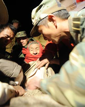 Soldiers rescue local residents at Yangyi Village, the epicenter of the earthquake, in Gedar Township of Damxung County in southwest China's Tibet Autonomous Region, in the early morning of Oct. 7, 2008. [Purbu Zhaxi/Xinhua] 