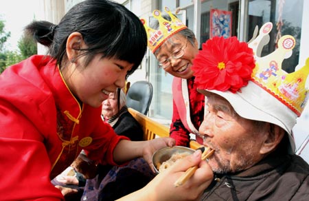 A waitress feeds an elder long life noodles at Luyuan Elder Apartment in Xuchang city, central China's Henan Province, Oct. 6, 2008. People throughout China started to celebrate the coming Double Ninth Festival, which is considered a traditional occasion to pay respect to the aged. The festival falls on the ninth day of the ninth month of the Chinese lunar calendar, or Oct. 7 this year. [Xinhua]