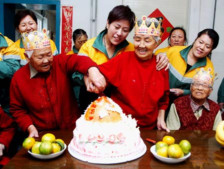 City cleaners and elders cut cake together at the Xinghai Park Rest Home of Dalian city, northeast China's Liaoning Province, Oct. 6, 2008. People throughout China started to celebrate the coming Double Ninth Festival, which is considered a traditional occasion to pay respect to the aged. The festival falls on the ninth day of the ninth month of the Chinese lunar calendar, or Oct. 7 this year. [Xinhua]