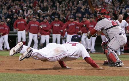 Boston Red Sox Jason Bay slides to score the game winning run as Los Angeles Angels Mike Napoli tries to tag him (R) during the ninth inning in Game 4 of their MLB American League Division Series baseball playoff at Fenway Park in Boston, Massachusetts, October 6, 2008. 