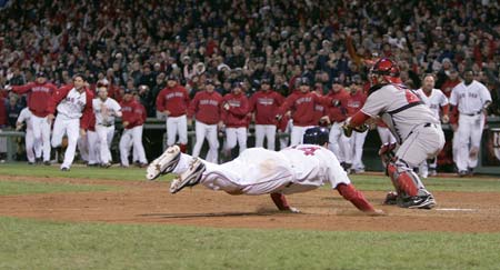Boston Red Sox Jason Bay slides to score the game winning run as Los Angeles Angels Mike Napoli tries to tag him (R) during the ninth inning in Game 4 of their MLB American League Division Series baseball playoff at Fenway Park in Boston, Massachusetts, October 6, 2008.