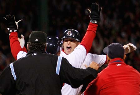 Boston Red Sox Jed Lowrie is congratulated by his teammates after hitting a series winning RBI against the Los Angeles Angels during the ninth inning of Game 4 of their MLB American League Division Series baseball playoff at Fenway Park in Boston, Massachusetts, October 6, 2008.