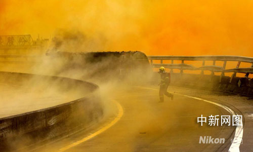 A firefighter works at the scene of a chemical spill from a truck carrying 29 tons of nitric acid in Ningbo City, in east China's Zhejiang Province on Tuesday, October 7th, 2008. [Photo: chinanews.com]