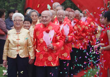 Hand-in-hand, old couples walk through the red carpet at the &apos;Golden Wedding&apos; ceremony in Changning District of East China&apos;s Shanghai Municipality Oct. 6, 2008. More than one hundred couples celebrate their 50 years of marriage in Changning District during the Double Ninth Festival. The festival is considered a traditional occasion to pay respect to the aged and falls on the ninth day of the ninth month of the Chinese lunar calendar, or Oct. 7 this year. [Xinhua]