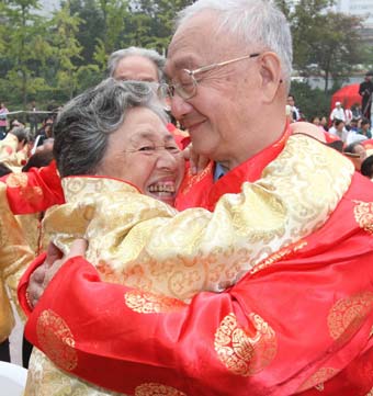 An old couple embraces to celebrate their fiftieth marriage anniversary at the &apos;Golden Wedding&apos; ceremony in Changning District of East China&apos;s Shanghai Municipality Oct. 6, 2008. [Xinhua]