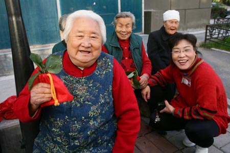 Wang Zhiying (front left), aged 80, receives the Zhuyu bag as a traditional gift given by community workers in Beijing Oct. 6, 2008. The Double Ninth Festival falls on the ninth day of the ninth month of the Chinese lunar calendar, or Oct. 7 this year. Chinese people celebrate the festival to pay respect to the aged. [Xinhua]