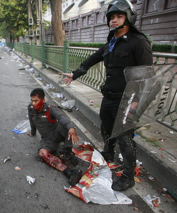 A policeman sits by the side of the road after being injured during clashes with anti-government demonstrators outside Parliament in Bangkok on October 7, 2008. Police fired tear gas at several thousand demonstrators attempting to block lawmakers&apos; access to parliament, heating up a political crisis that has gripped the country for six weeks and led to the resignation of the deputy prime minister on Tuesday. [Agencies]