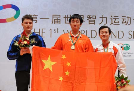 China's Bu Xiangzhi (C) shows his national flag during the awarding ceremony for the men's rapid chess individual in the First World Mind Sports Games in Beijing, capital of China, Oct. 8, 2008. Bu Xiangzhi defeated Korobov Anton (L) of Ukraine and claimed the title. Zhang Zhong (R) of Singapore took the bronze.
