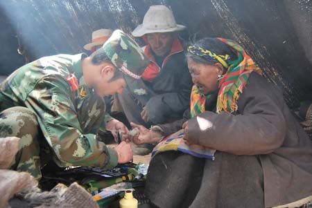 An armed police soldier help a villager dress her wound in Damxung County, southwest China's Tibet Autonomous Region, on Oct. 7, 2008. More than 350 armed police officials and soldiers were dispatched to attend the quake-relief work immediately after a 6.6-magnitude earthquake jolted Damxung County near Lhasa at 4:30 p.m. (Beijing Time) on Monday.(Xinhua/Cheng Yi)