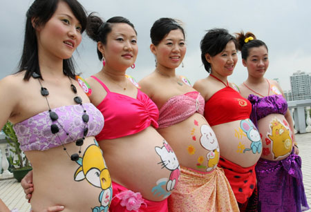Competitors show their painted bellies at a body-painting competition for pregnant women in Haikou, South China&apos;s Hainan Province on October 8, 2008. [Photo: CFP] 