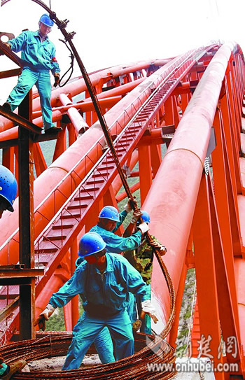 Workers untie the last wirerope used for securing the steel tubes of the Zhijinghe River Bridge, located at Badong county in central China&apos;s Hubei Province, on Tuesday, October 6th, 2008. The bridge was erected about one thousand meters above the ground. Its lofty yet risky location has made the construction of it ever so tough. 