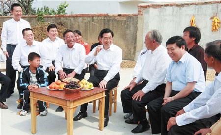 President Hu Jintao talks with villagers during a visit to Xiaogang village, Fengyang county, Anhui province, on Sept 30. [Xinhua] 