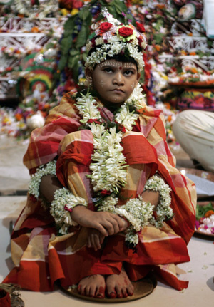 Indian girl Priyanka Banerjee, portraying Hindu goddess Durga, watches devotees during the traditional "Durga Puja" religious festival in Kolkata, capital of the eastern Indian state of West Bengal, October 8, 2008. 