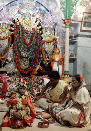 An Hindu woman worships Indian girl Priyanka Banerjee (L), who is portraying Hindu goddess Durga, in front of an idol during the traditional &apos;Durga Puja&apos; religious festival in Kolkata, capital of the eastern Indian state of West Bengal, October 8, 2008. [Xinhua]