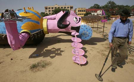 A security personnel checks with a metal detector near to an effigy of demon king Ravana on the eve of Hindu festival of Dussehra in Jammu October 8, 2008.