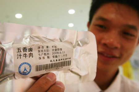 An employee shows a bag of beef, a kind of the space food for Chinese astronauts during their space mission, in a collectiles shop in Beijing October 7, 2008. [CFP] 
