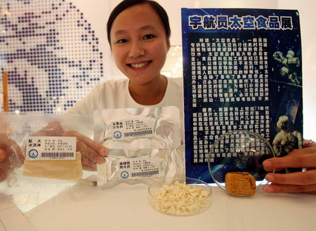 An employee shows space food for Chinese astronauts during their space mission in a collectibles shop in Beijing October 7, 2008. [CFP] 