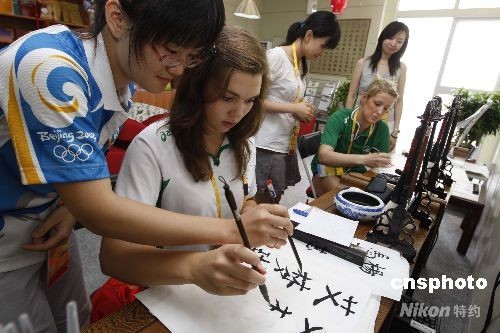  An Irish athlete (2nd from L) learns to write Chinese calligraphy at the Olympic villiage in Beijing on July 29, 2008, during the Beijing Olympics.