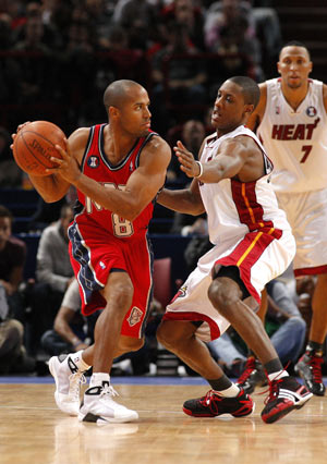 New Jersey Nets' Eddie Gill (L) is defended by Miami Heat's Mario Chalmers during the third quarter of their NBA pre-season basketball game in Paris October 9, 2008. 
