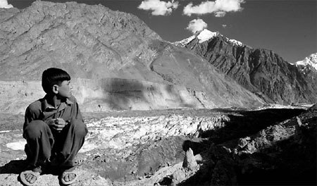 A boy looks out to the Hopar glacier in the central Hunza region, Pakistan, in July last year. Research has shown that the Himalayan glaciers may disappear in 40 to 50 years because of climate change.