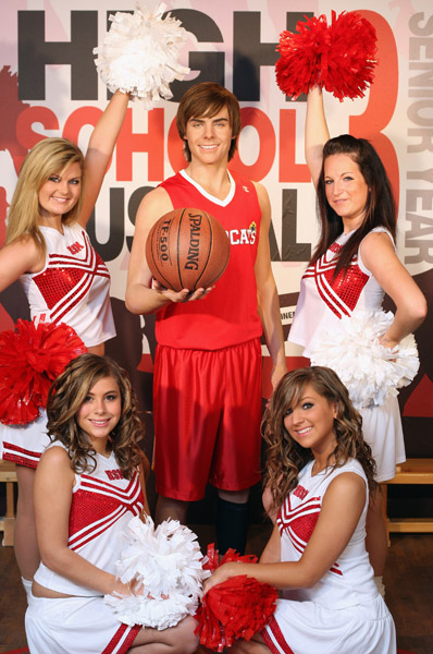 A wax model of US actor Zac Efron stands at centre with cheerleaders from British dance troupe 'Storm' poses for photographs with the wax model as it is unveiled at Madame Tussauds waxworks museum in London, Thursday Oct. 9, 2008. 