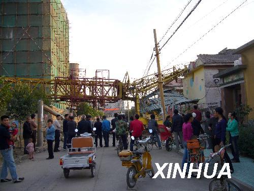 Local villagers look on at the site after a crane fell on a kindergarten in Liujia Village of Zhangdian District in Zibo City, east China's Shandong Pronvince, Oct. 10, 2008.