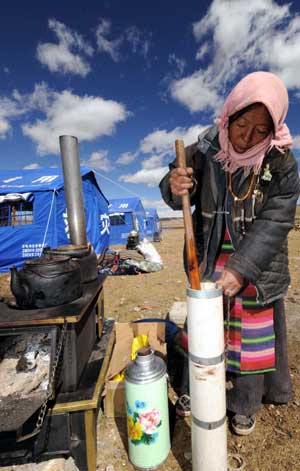 A Tibetan woman makes ghee tea near the relief tent in Yangyi Village of Gedar Township in Damxung County, an outer county of Lhasa, capital of southwest China&apos;s Tibet Autonomous Region, Oct. 10, 2008. 
