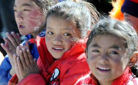 Tibetan school pupils enjoy the performances at a Primary School of Gedar Township in Damxung County, an outer county of Lhasa, capital of southwest China's Tibet Autonomous Region, Oct. 10, 2008. [Xinhua]