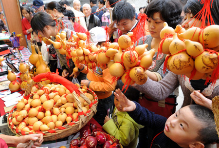  People select gourd handicrafts during the 4th agriculture carnival in Nanjing, capital of east China's Jiangsu Province, Oct. 11, 2008. [Xinhua]