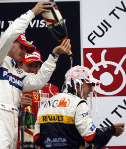 Renault driver Fernando Alonso (right) celebrates on the podium with BMW-Sauber's Robert Kubica of Poland (left) and Ferrari's Kimi Raikkonen of Finland after taking the checkered flag on winning the Formula One Japanese Grand Prix at Fuji Speedway in Oyama, at the foot of Mount Fuji, yesterday.