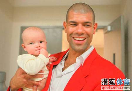 Shane Battier of the Houston Rockets holds his four-month old son Zeke Edward as he watches a pre-season game between Rockets and Spurs at the Toyota Center Thursday night. The Rockets made it 2-for-2 during the exhibition season.[sohu.com]