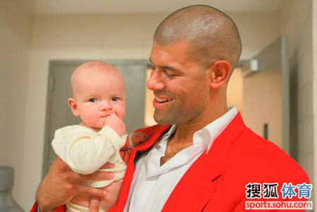 Shane Battier of the Houston Rockets holds his four-month old son Zeke Edward as he watches a pre-season game between Rockets and Spurs at the Toyota Center Thursday night. The Rockets made it 2-for-2 during the exhibition season.[sohu.com] 
