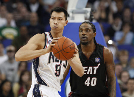New Jersey Nets' Yi Jianlian (L) looks to pass over Miami Heat's Udonis Haslem during the first quarter of their NBA pre-season basketball game in London Oct. 12, 2008. [Xinhua/Reuters]