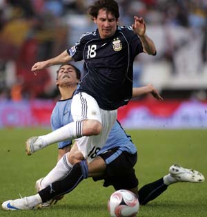 Argentina's Lionel Messi (front) vies with Uruguay's Martin Caceres during their FIFA World Cup 2010 qualifying football match held in Buenos Aires, capital of Argentina, October 11, 2008. Argentina won 2-1. [Martin Zabala/Xinhua]