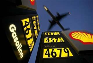Gasoline prices are advertised at a gas station near Lindbergh Field as a plane approaches to land in San Diego, California in this June 1, 2008 file photo. To match Reuters Witness story OIL/TAXI in which, Daniel Fineren, who is a senior energy correspondent, describes his recent encounter with a Spanish taxi driver on the way home from the World Petroleum Congress.[Reuters] 