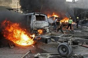 Men try to put fire out after a car bomb blast in Abu Dshir in Baghdad, Iraq, Friday, Oct. 10, 2008. [Loay Hameed/AP Photo] 