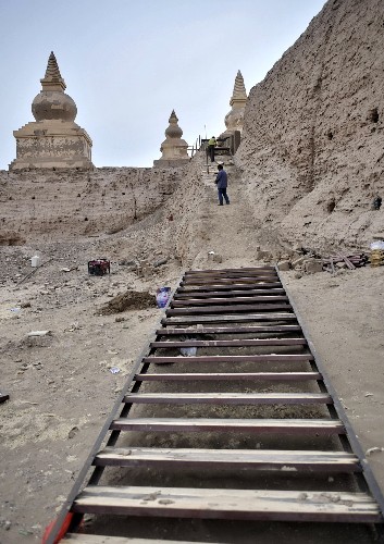 Workers build the plank road for visitors to climb up to the ancient city in the far west of Inner Mongolia on October 7, 2008. 'Black Water City', located in the Gobi desert in the far west of Inner Mongolia, is under restoration recently.