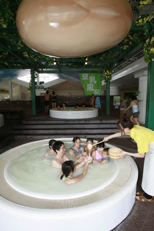 An employee adds soy milk into a soy milk hot spring in Hakone, Japan, Oct. 12, 2008. The day is the soy milk festival of Japan. A hot spring holiday inn in Hakone Kowakien provided soy milk hot spring for guests. (Xinhua/Ren Zhenglai)