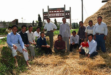 The villagers take pictures at the entrance to Xiaogang Village.